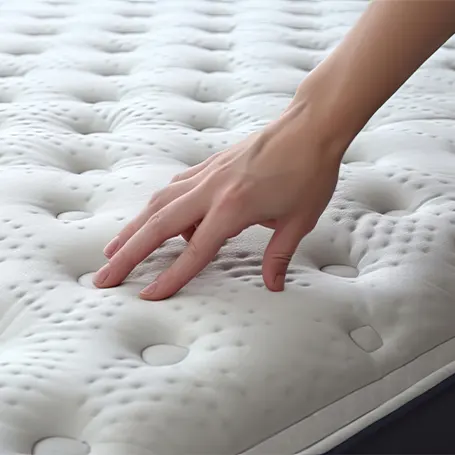 An image of a hand pressing on a memory foam mattress