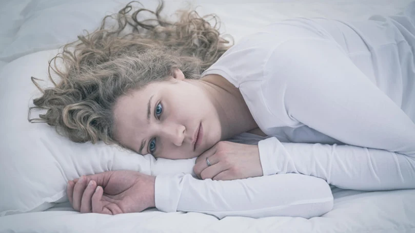 an image of a depressed woman laying in a bed