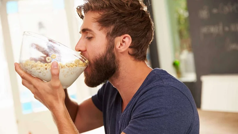 uma imagem de um homem a comer muito