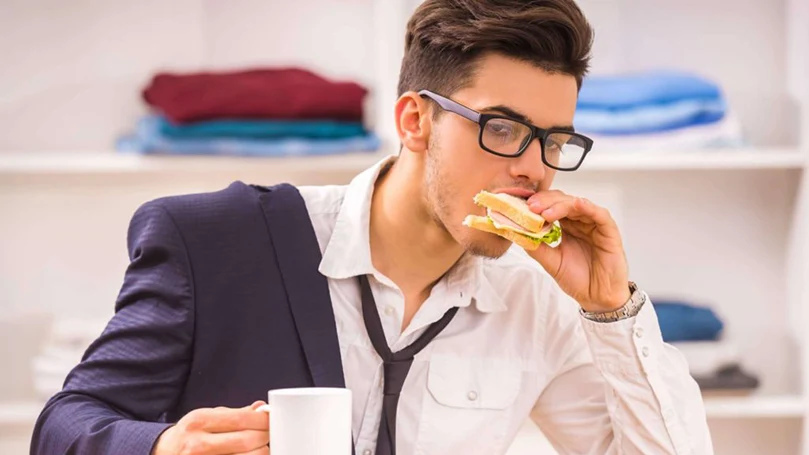 uma imagem de um homem a comer depressa para chegar a tempo ao trabalho