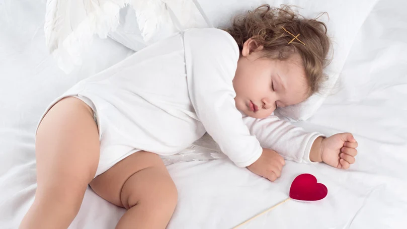 an image of a baby girl sleeping on a bed