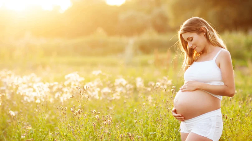 uma mulher grávida num campo