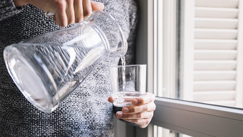 an image of a woman pouring herself a glass of water