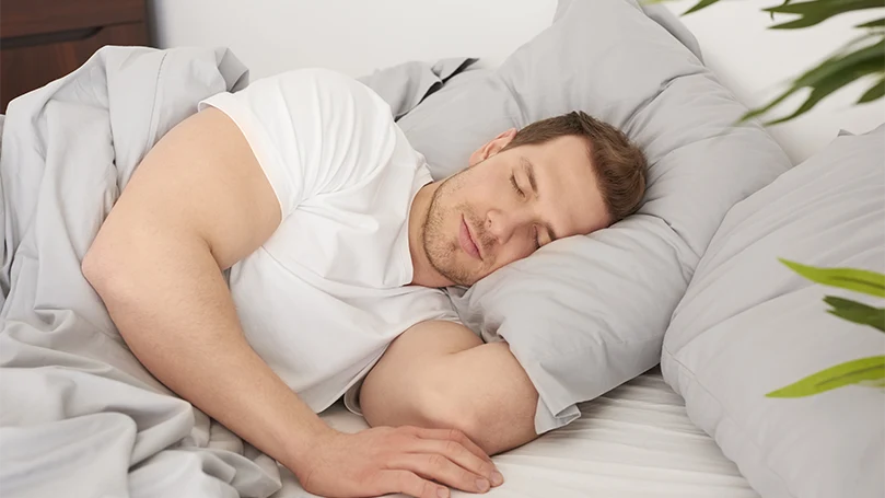 um homem a dormir confortavelmente na sua cama