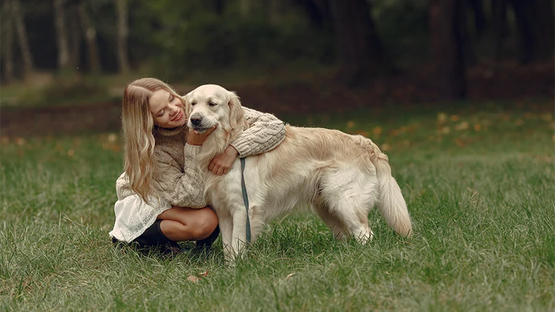 uma imagem de uma mulher a abraçar um cão