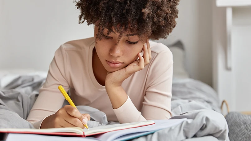 An image of a woman writing down her dreams in a dream diary