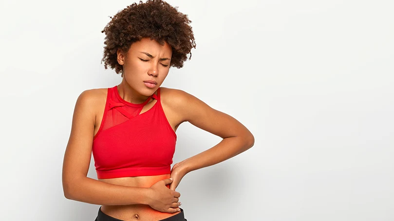 A young woman holding her hip due to pain