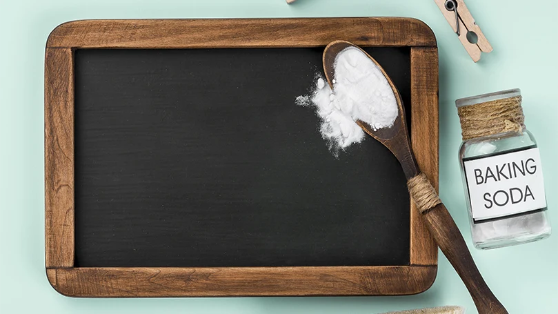 a spoonful of baking soda on a wooden table