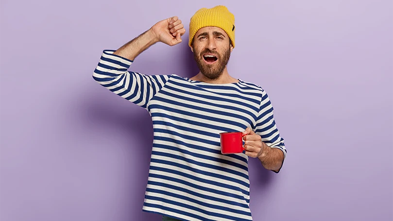 Uma imagem de um homem a começar a sua manhã com uma chávena de café.