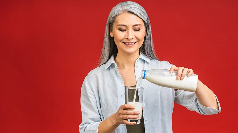 Uma imagem de uma mulher a beber um copo de leite.