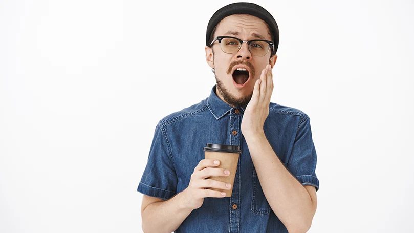 Um jovem a bocejar antes de uma sesta de café