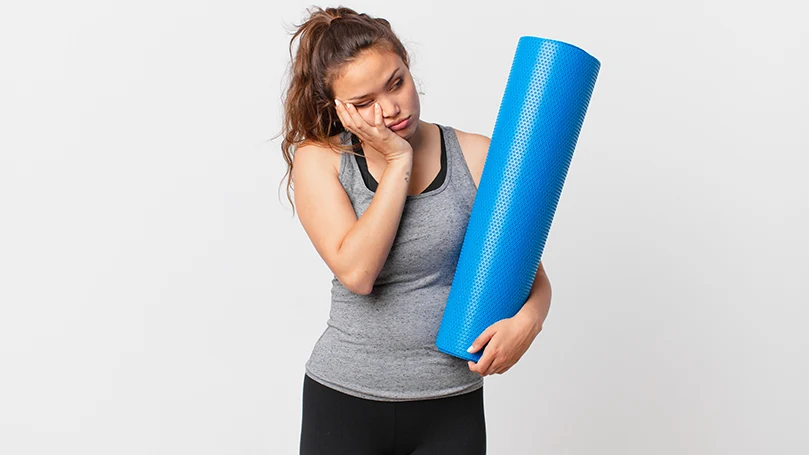 Uma imagem de uma jovem mulher a tentar manter-se acordada depois de uma sessão de exercício físico.