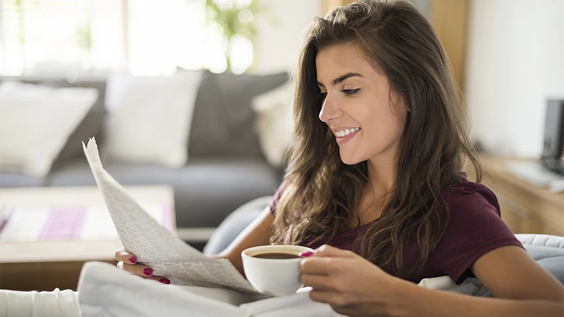 Uma imagem de uma jovem mulher a beber o seu café.