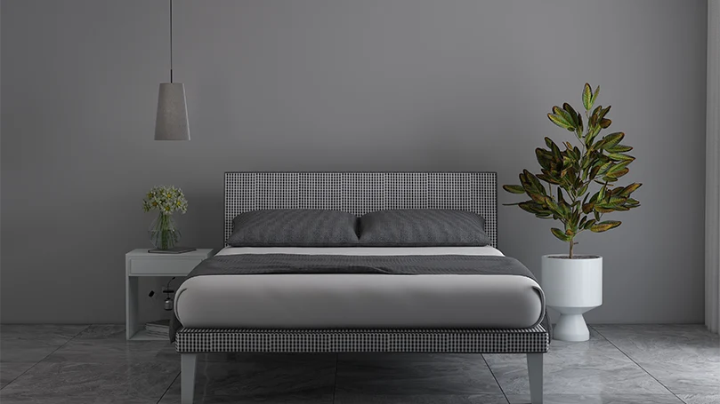 An image of a simple bed frame in a grey room