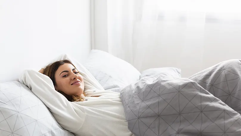 Uma mulher descontraída na cama.