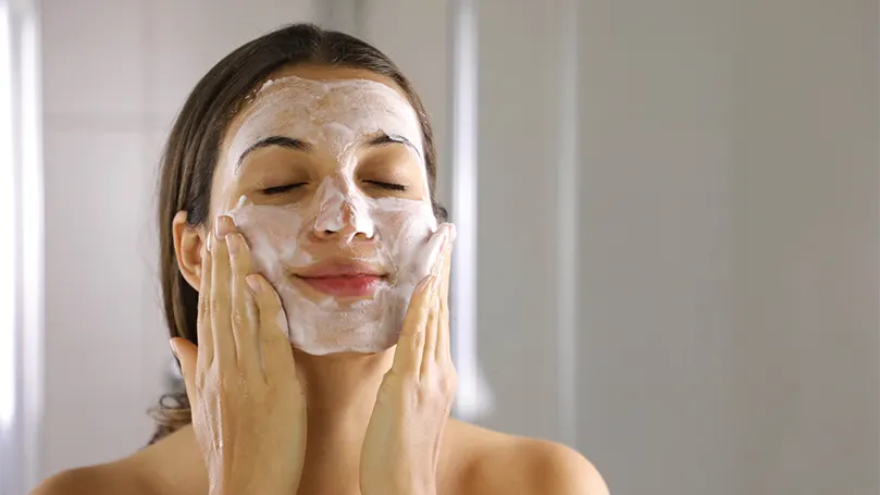 An image of a woman washing her face.