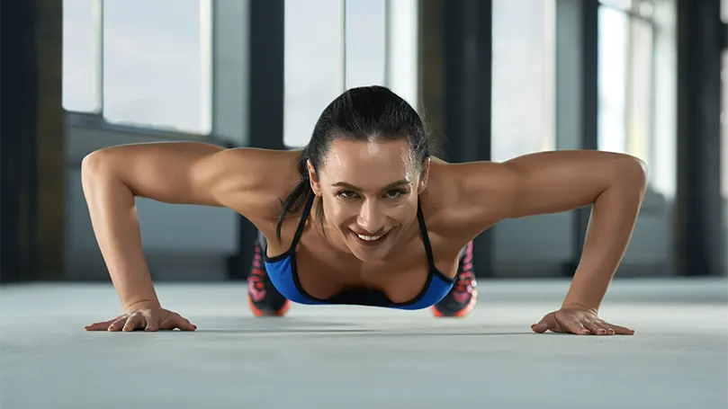 Uma imagem de uma jovem mulher a fazer flexões.