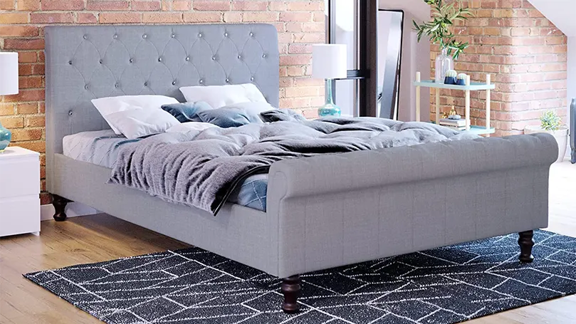 An image of an elegant sleigh bed in a bedroom.