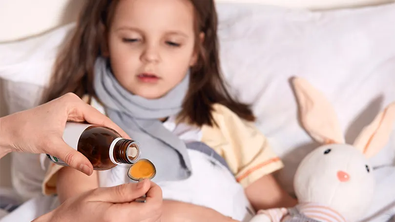 A girl getting a cough syrup.