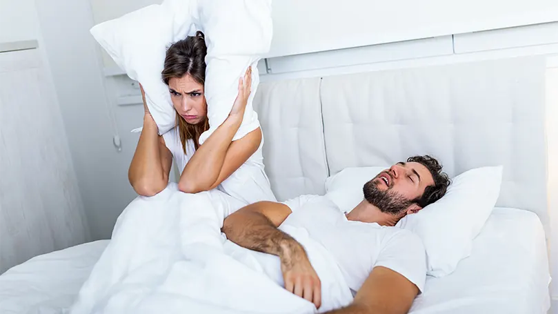 Uma mulher não consegue dormir devido a um homem que ressona na cama enquanto dorme