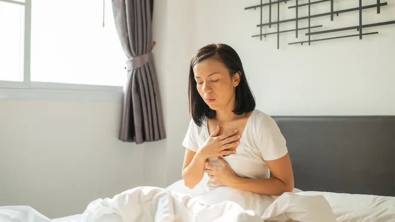 Uma mulher acordada na cama por um despertar abrupto