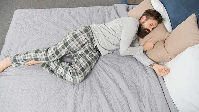 An image of a young bearded man in a deep sleep stage.