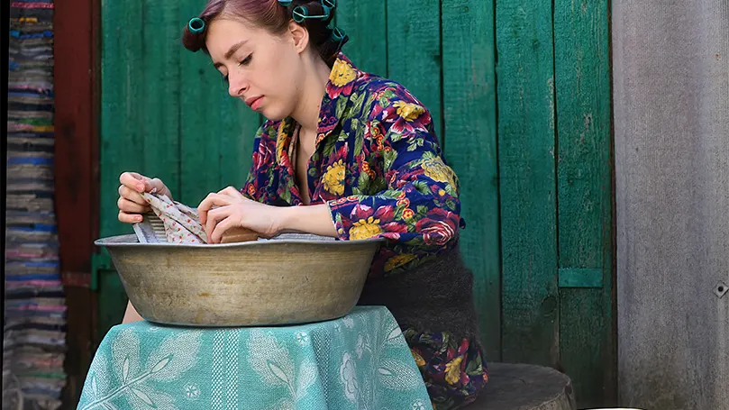 An image of a young woman soaking pajamas in lukewarm water.