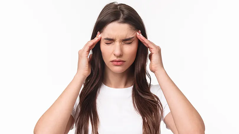 An image of a young woman suffering from headache.