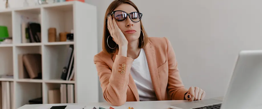 Mulher a dormir a sesta no trabalho de secretária