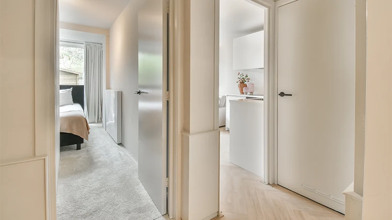 An image of a bedroom rug connecting hallway and two rooms.