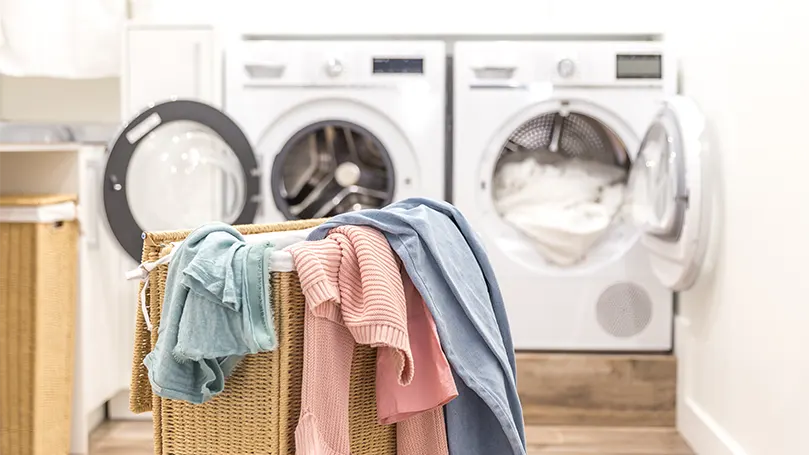 An image of a laundry basket with clothes for washing.