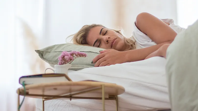 An image of a woman sleeping and breathing in bed.