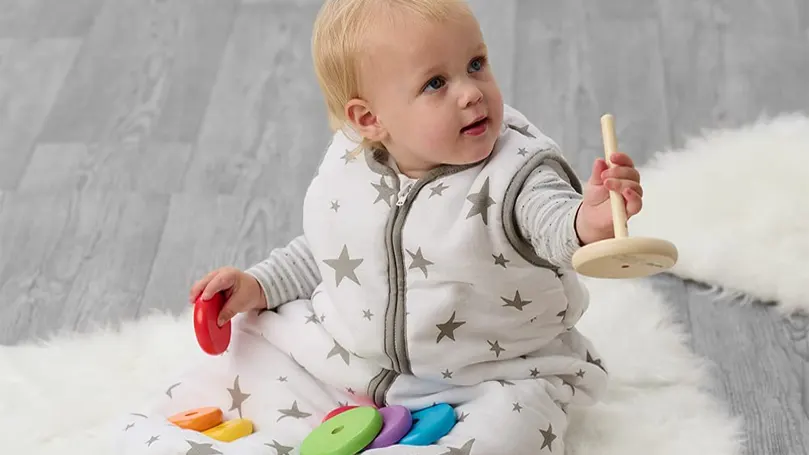 An image of a baby playing in a sleep bag.