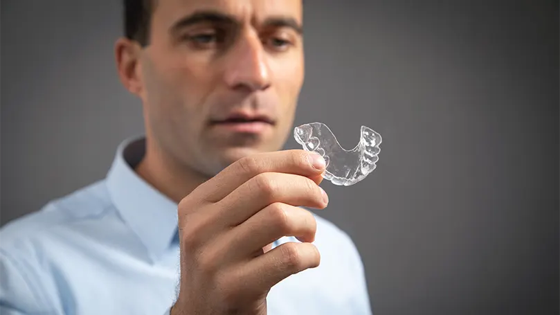 An image of a man showing his mouth guard.