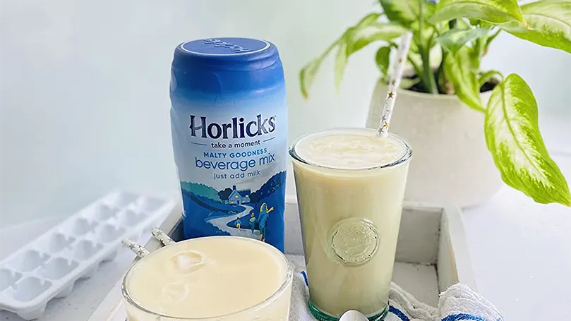 Horlicks num copo com uma palhinha.