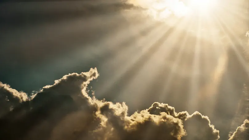 Uma imagem da luz do sol a incidir sobre algumas nuvens