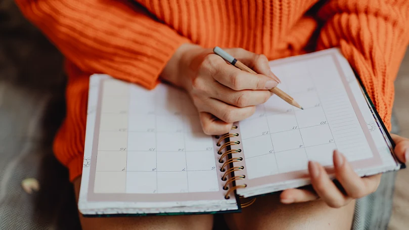 A woman making notes in a diary.