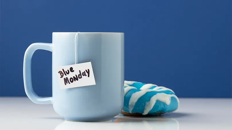 An image of a cup of tea and a doughnut next to it