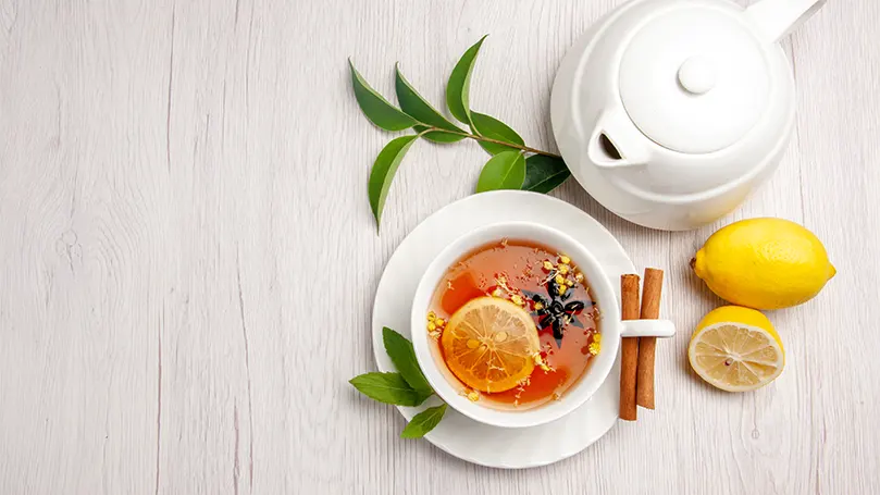 An image of a cup of herbal tea with milk on the side