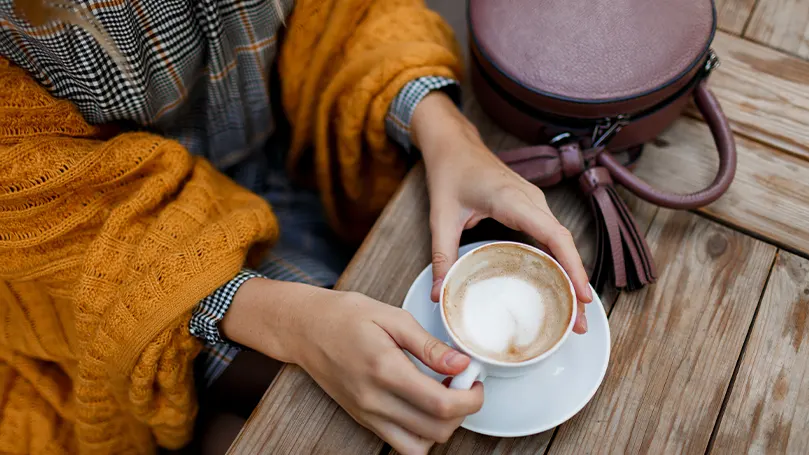 Uma imagem de uma pessoa a beber café no exterior