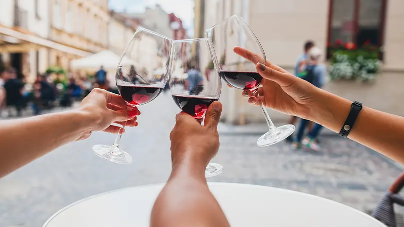 An image of three people holding wine glasses.