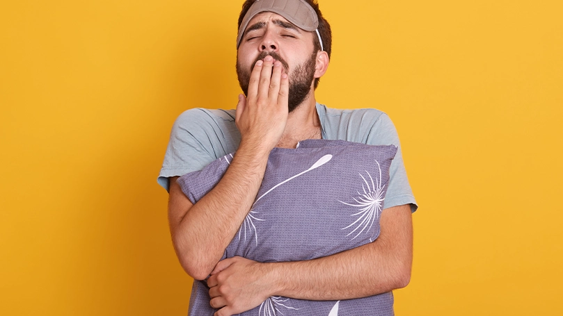 Uma imagem de um homem que não dormiu bem e está a bocejar