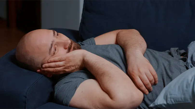 Uma imagem de um homem na cama, preocupado e incapaz de dormir