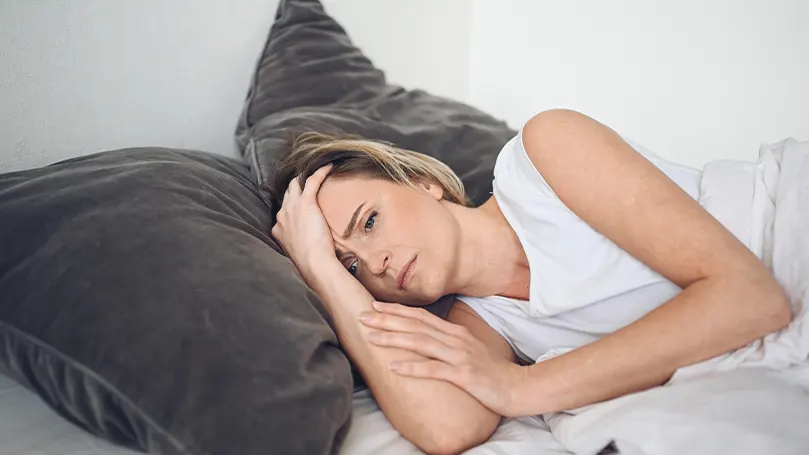 Uma imagem de uma mulher stressada na cama