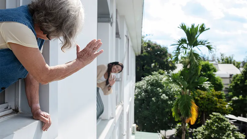 Uma imagem de uma mulher a acenar ao vizinho