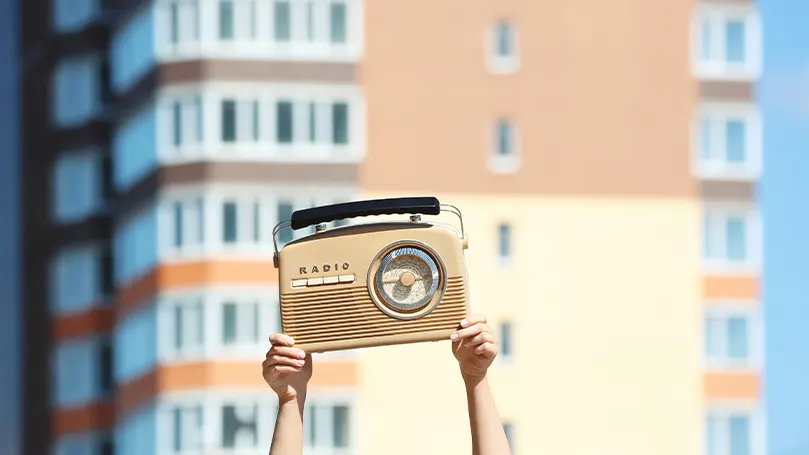 Uma imagem de uma pessoa a segurar um rádio.