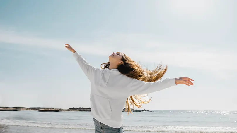 An image of a woman frolicking near the coast