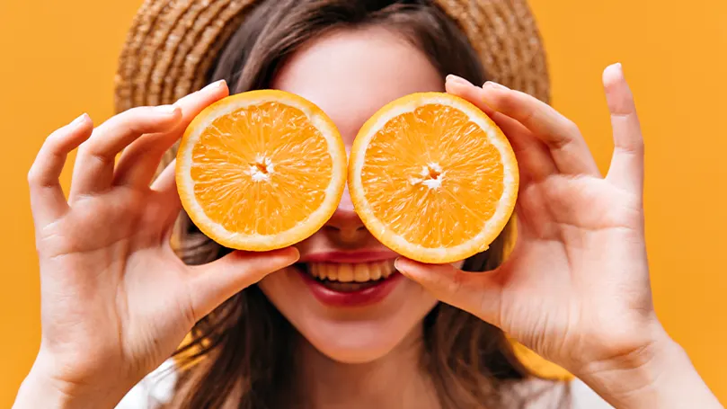 An image of a woman holding oranges.