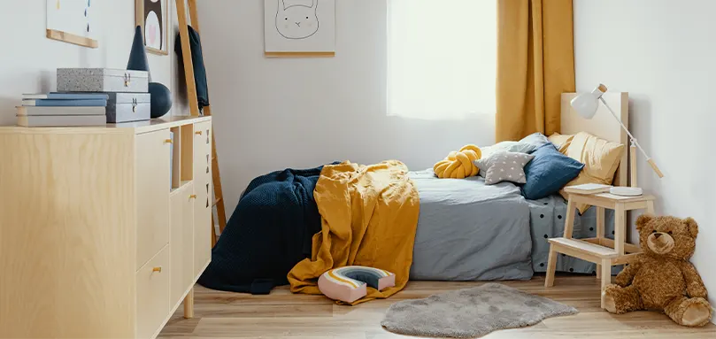 Quarto com cama de madeira com mobiliário macio azul-marinho e amarelo.