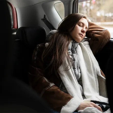 Uma imagem de uma mulher a dormir no seu carro.